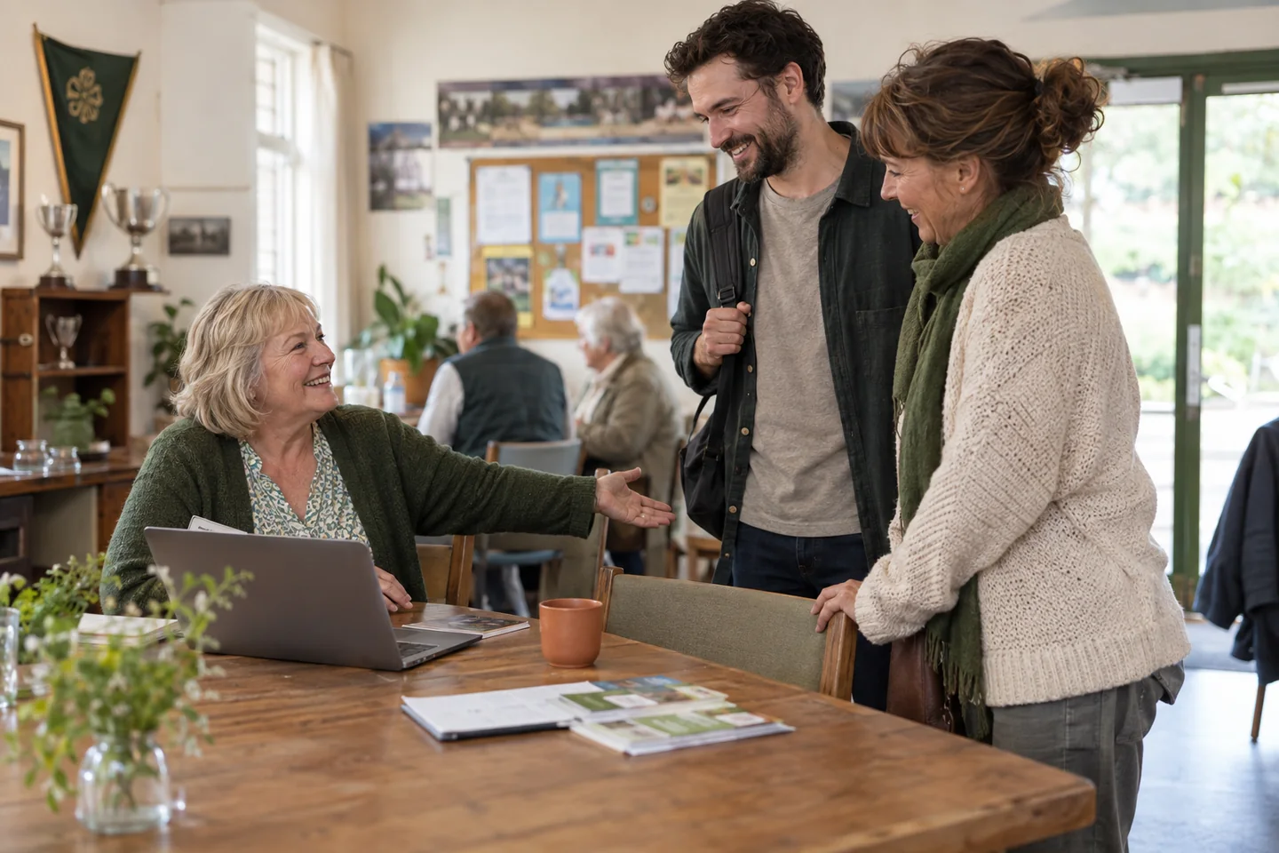 A volunteer welcomes two prospective members to the club