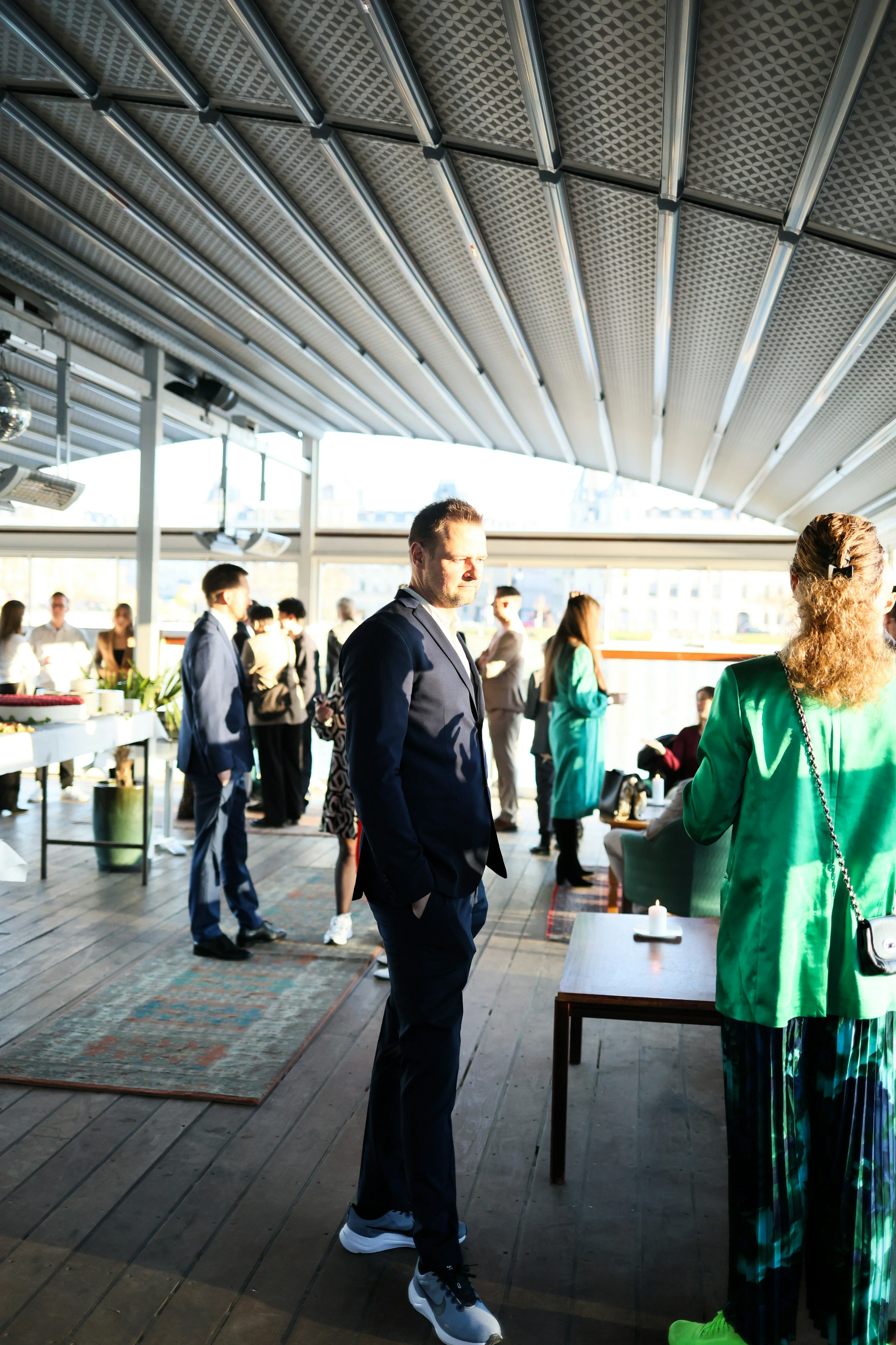People mingling at a daylight business gathering beneath a retractable roof.